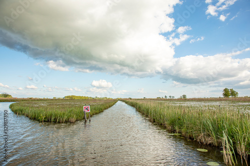 Low clouds above a river in the reedlands in the Nieuwkoop lakes in the Netherlands. photo