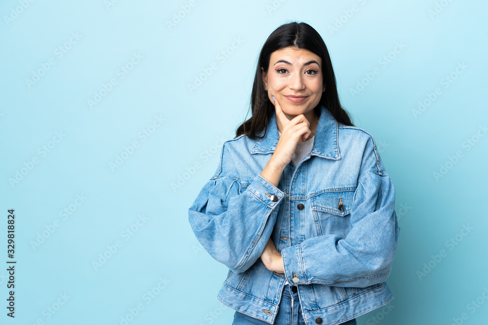 Young brunette girl over isolated blue background and thinking Young brunette girl over isolated blue background and thinking