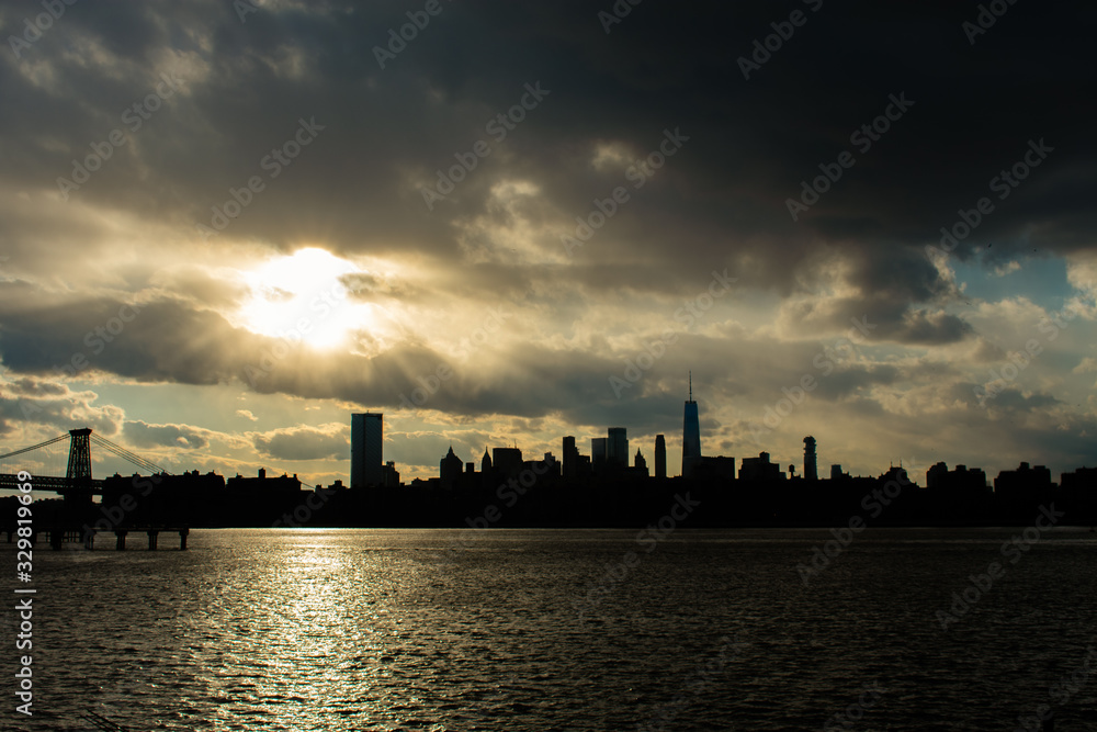 Lower Manhattan Skyline on the East River in New York City during Sunset with Skyscraper Silhouettes