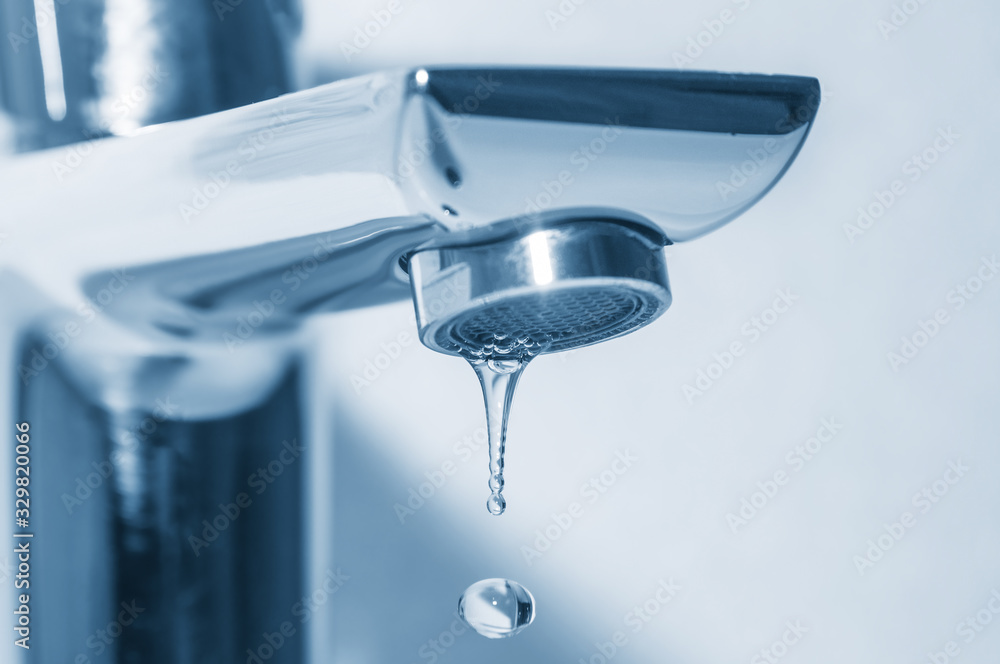 Metal tap and water drops close up on blue background Metal tap and water drops close up on blue background
