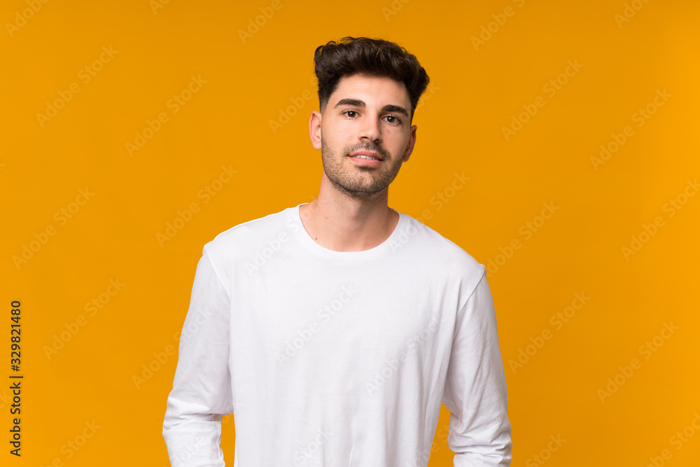 Fototapeta premium Young man over isolated orange background laughing