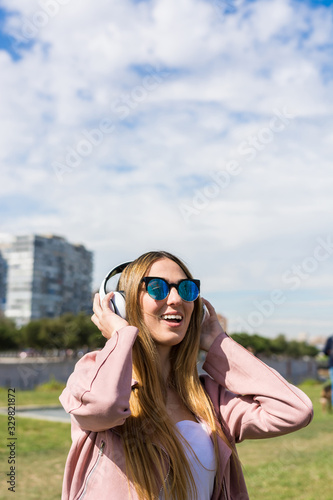 Young and happy girl is dancing while listening to music