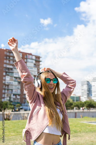 Young and happy girl is dancing while listening to music
