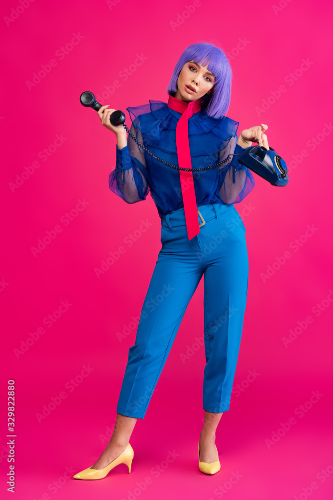 fashionable girl in purple wig holding retro phone, on pink fashionable girl in purple wig holding retro phone, on pink