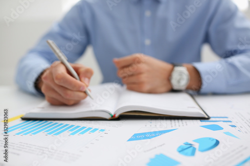 Businessman holding pan in hand financial statistics documents infographics office table closeup. Internal inspector sum check, investigation exchange market earnings savings loan and credit concept