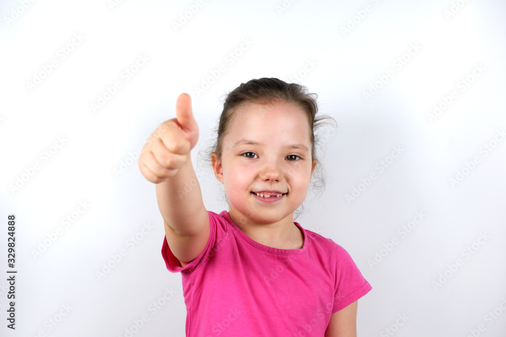 Smiling cheerful little preschooler caucasian girl shows hand gesture of agree or approval. Recommendation, advice, approval, good product or service for children concepts. Smiling cheerful little preschooler caucasian girl shows hand gesture of agree or approval. Recommendation, advice, approval, good product or service for children concepts.