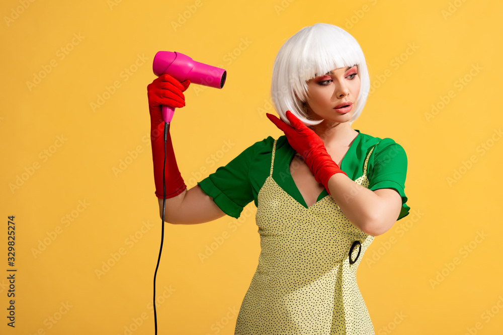 pop art girl in white wig using hair dryer, isolated on yellow pop art girl in white wig using hair dryer, isolated on yellow