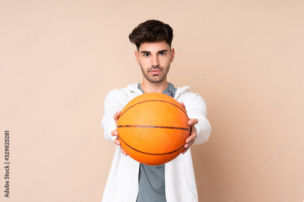 Young man over isolated background playing basketball Young man over isolated background playing basketball