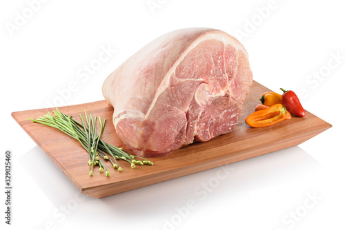Raw pernil (pernil asado, pernil al horno, roast pork butt). A slow-roasted marinated pork leg or pork shoulder, ready to be cooked. On a cutting board with peppers aside, isolated on white background