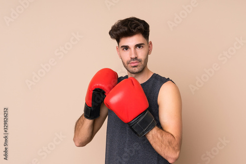 Young sport man over isolated background with boxing gloves © luismolinero
