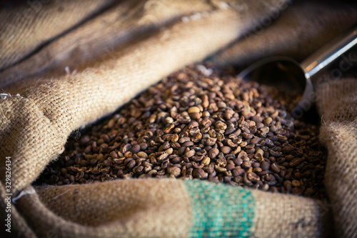 Big beige linen bag with fresh matte coffee beans blurred foreground © Linda