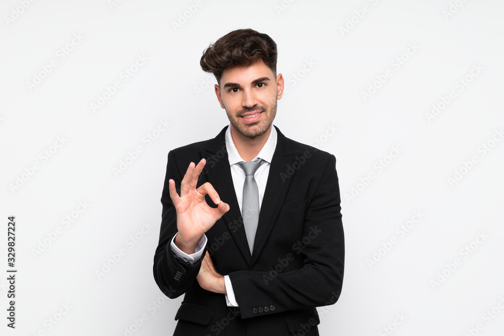 Young businessman over isolated white background showing an ok sign with fingers Young businessman over isolated white background showing an ok sign with fingers