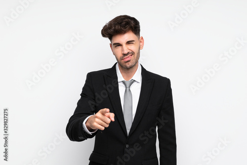 Young businessman over isolated white background points finger at you