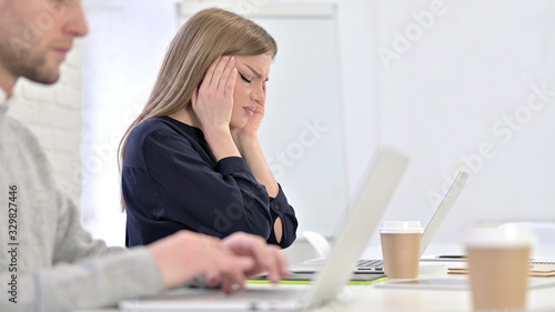 Tired Creative Female Professional having Headache in Office