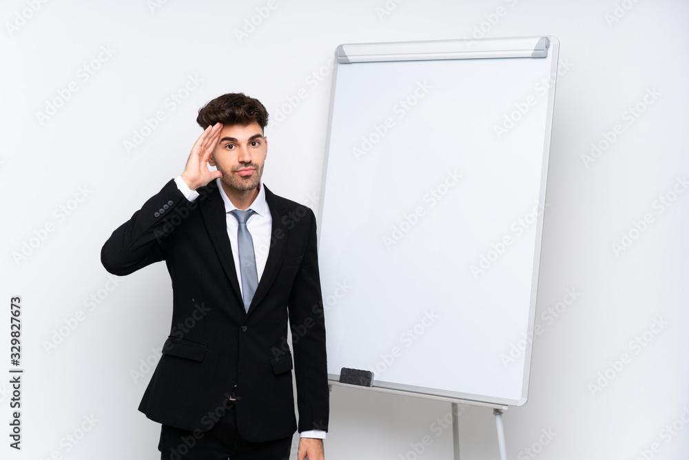 Young businessman giving a presentation on white board with surprise and shocked facial expression Young businessman giving a presentation on white board with surprise and shocked facial expression