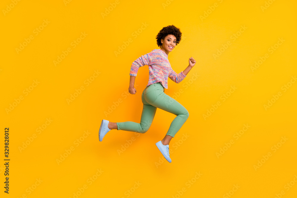 Full length profile side photo of funky dreamy cheerful afro american girl jump run hurry want black friday discount wear green good fall spring outfit isolated over shine color background Full length profile side photo of funky dreamy cheerful afro american girl jump run hurry want black friday discount wear green good fall spring outfit isolated over shine color background