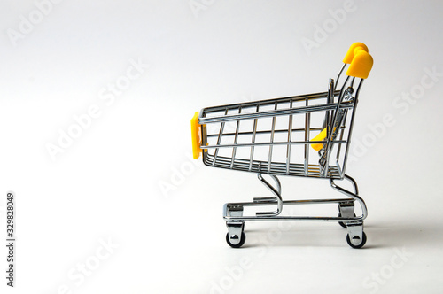 Cart for shopping yellow on a white background. Concept holiday shopping, sales, prices and discounts. © queen1987