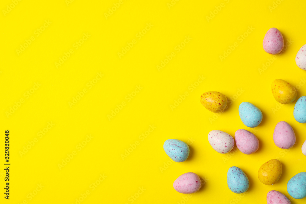 Obraz premium Small Easter eggs on yellow background, space for text