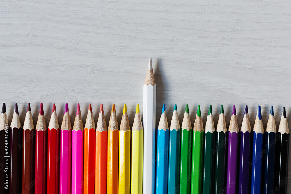 Row of colorful pencils on white wooden background top view. Education concept. Row of colorful pencils on white wooden background top view. Education concept.