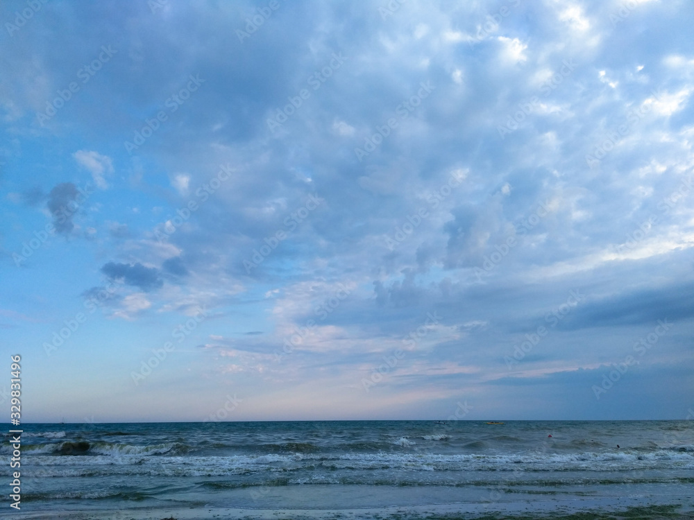 Blue clouds over the waves of the sea