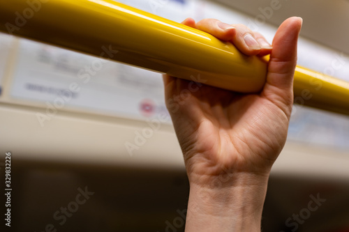 closeup woman hand holding handrail (grip) inside a train in London. Virus hygiene and safety. photo