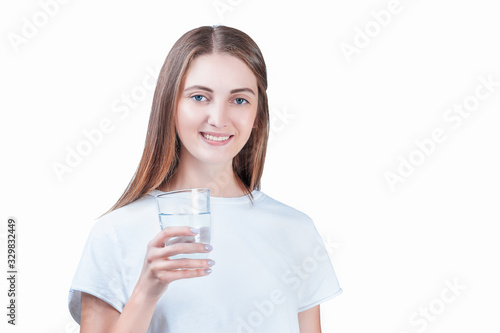 happy young woman in white t-shirt holding a glass of water in her hands and smiling