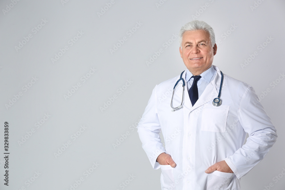Portrait of senior doctor against light background Portrait of senior doctor against light background