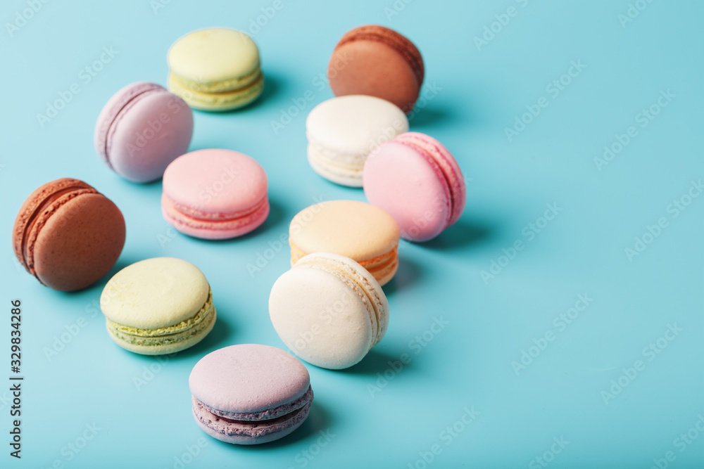 Macaroni cookies of different colors are scattered on a blue background. Macaroni cookies of different colors are scattered on a blue background.