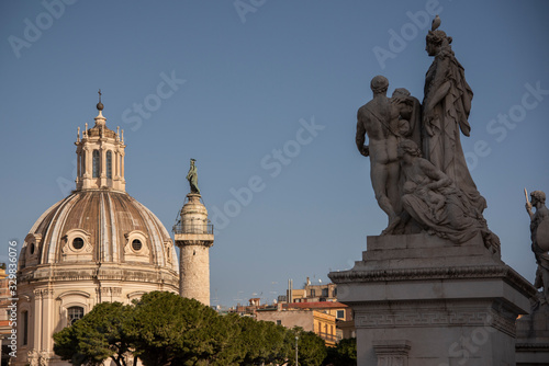 Sculptural group on the altar of the Fatherland called "La Concordia" with a view of the church of the most holy name of Maria al Foro di Traiano, with the Trajan column, Rome, Italy.