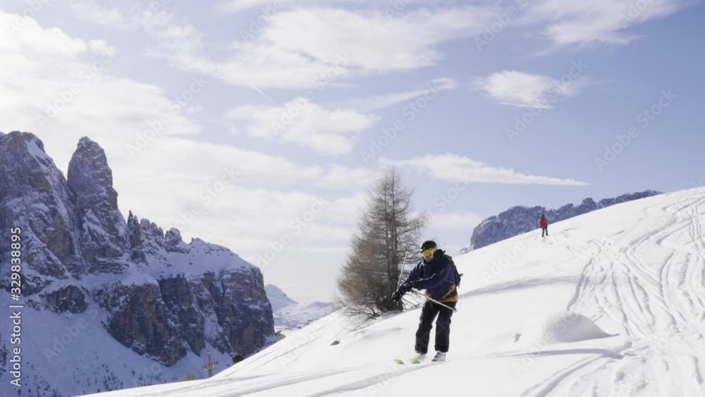 FOLLOW CLOSE UP: Happy skier having fun skiing backcountry on a sunny winter day in snowy mountains. Extreme freeride skier riding fresh powder snow off piste in mountain ski resort in dolomites Italy FOLLOW CLOSE UP: Happy skier having fun skiing backcountry on a sunny winter day in snowy mountains. Extreme freeride skier riding fresh powder snow off piste in mountain ski resort in dolomites Italy