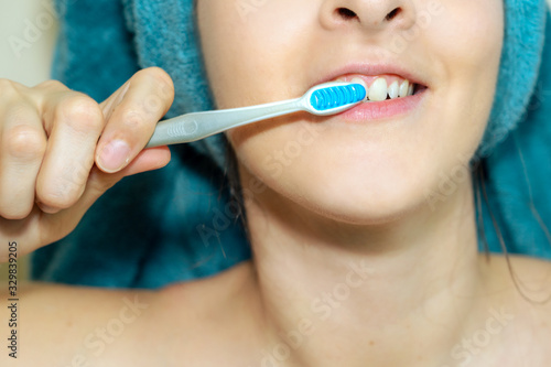 woman washing her teeth after shower daily routine