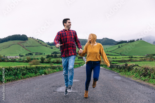guy and girl are walking along the road in the mountains. hold h