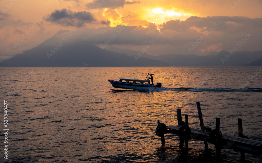 bot traveling on lake Atitlan, Guatemala at sunset bot traveling on lake Atitlan, Guatemala at sunset