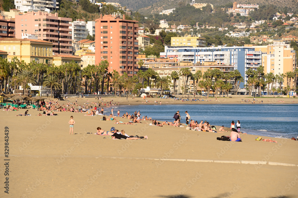 Malaga, Spain - March 4, 2020: Bathers on the beach of La Malagueta in the city of Malaga. Malaga, Spain - March 4, 2020: Bathers on the beach of La Malagueta in the city of Malaga.