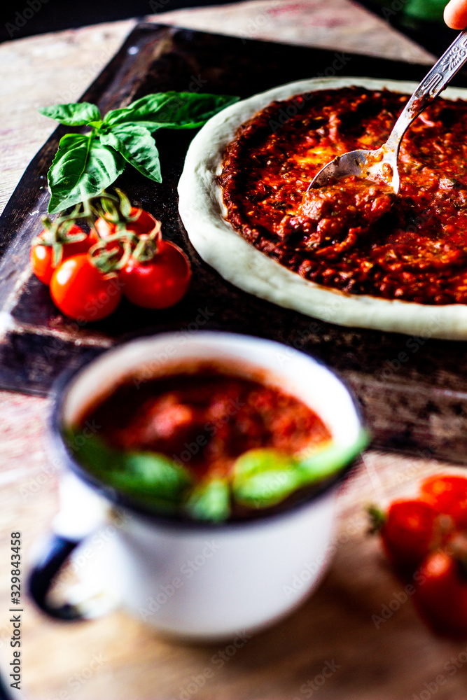 Adding pizza tomato sauce on the raw dough. Italian pizza preparation. Adding pizza tomato sauce on the raw dough. Italian pizza preparation.