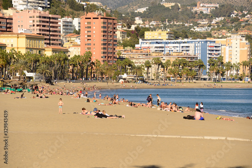 Malaga, Spain - March 4, 2020: Bathers on the beach of La Malagueta in the city of Malaga.
