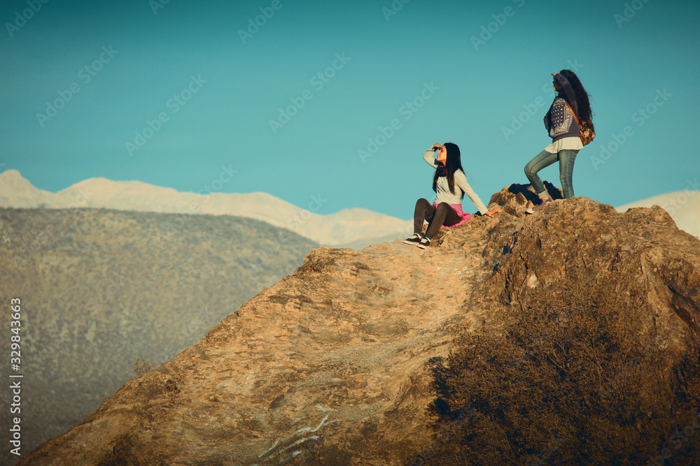Dos mujeres jóvenes mirando desde una montaña Dos mujeres jóvenes mirando desde una montaña