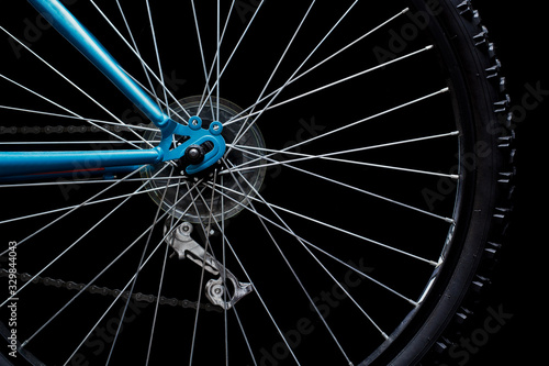Fotografie Rear bicycle wheel on black. Low key image.