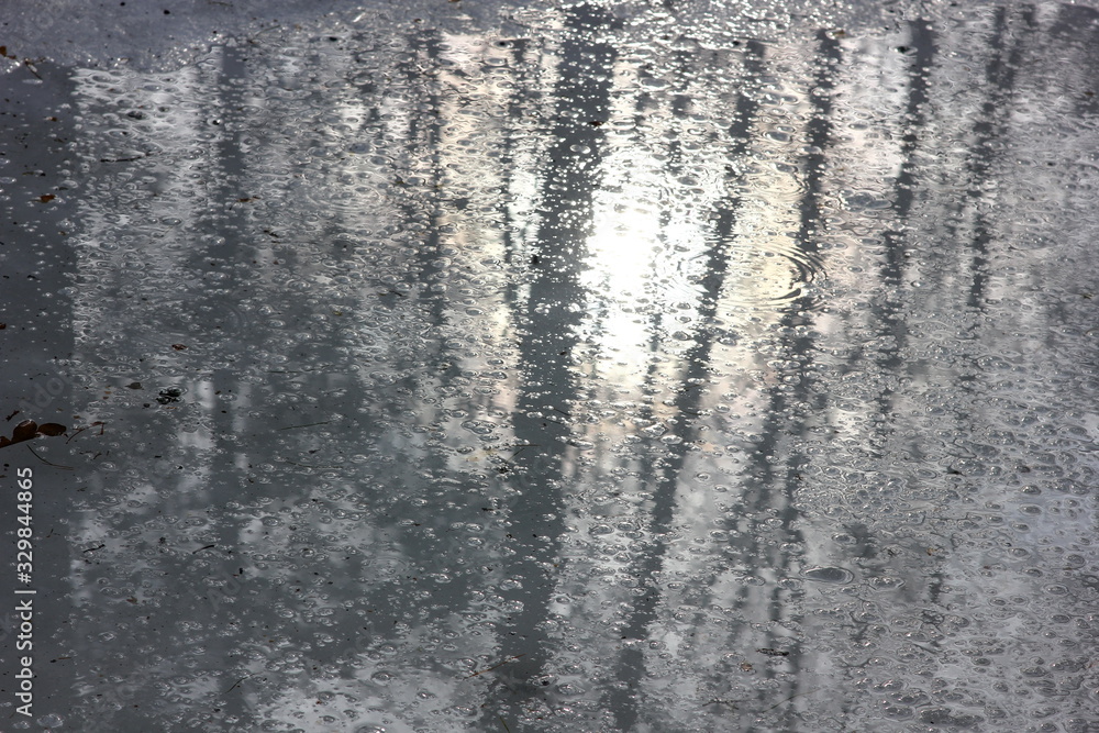 blurred reflection of trees in a spring stream against the background of melting snow blurred reflection of trees in a spring stream against the background of melting snow
