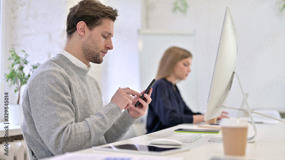 Obraz premium Serious Creative Professional Using Smartphone in Office