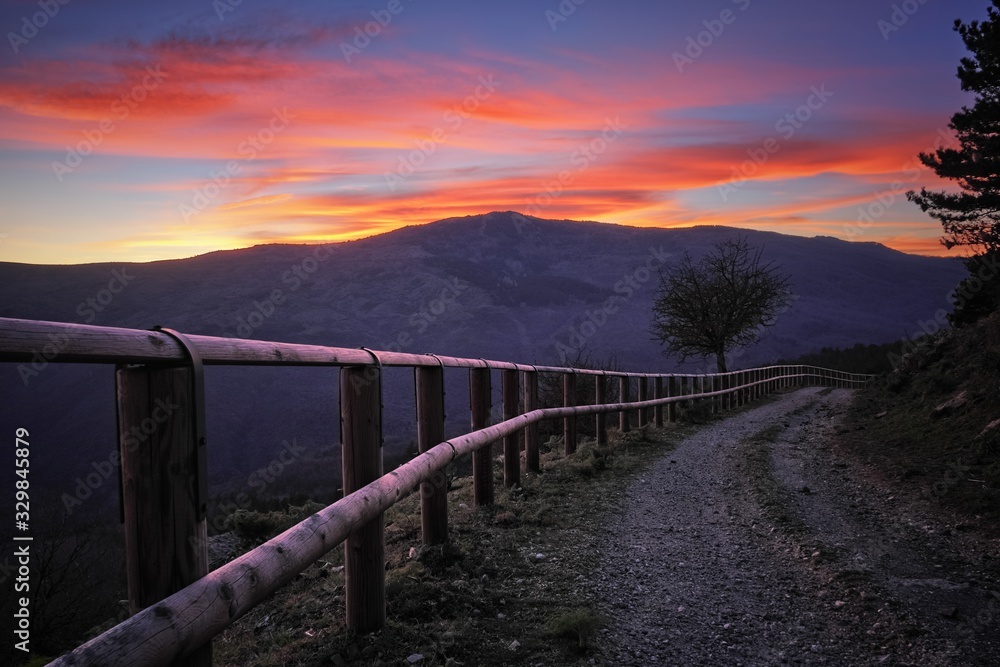 Wooden Fence Along Dirt Road At Twilight
