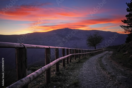 Wooden Fence Along Dirt Road At Twilight