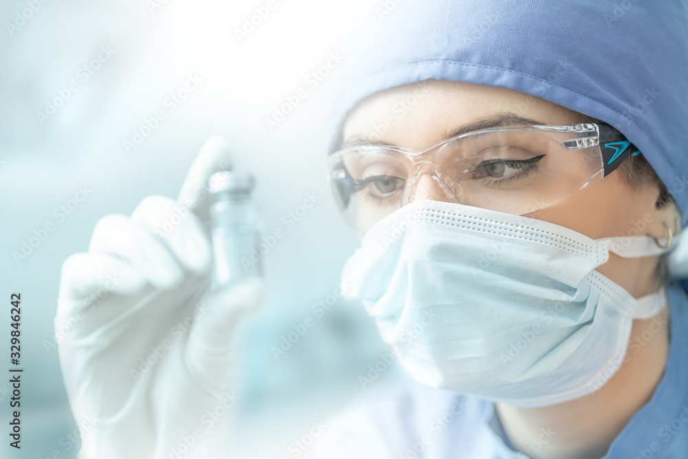 Female laboratory technician with ampoule of virus vaccine Female laboratory technician with ampoule of virus vaccine