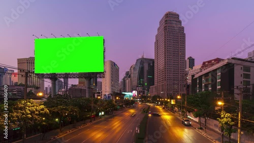 Time lapse: Billboard with green screen and city traffic light background at day to night. 4K Resolution.