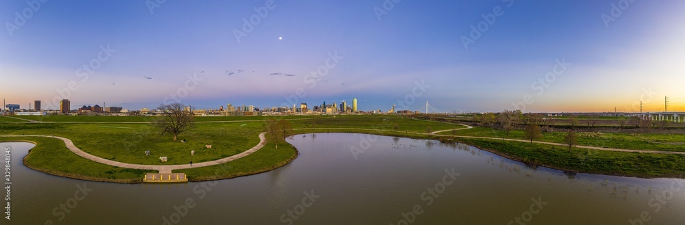 Panoramic aerial drone picture of Dallas skyline and Trammel Crow Park at sunset in winter