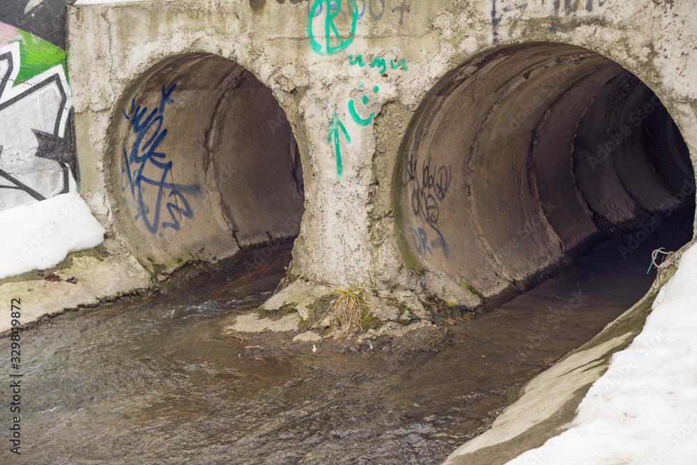 Drain pipe or effluent or sewer release wastewater into river. Winter. Drain pipe or effluent or sewer release wastewater into river. Winter.