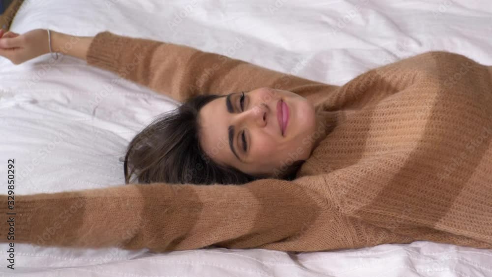 Happy woman falling on bed slow motion smiling Happy woman falling on bed slow motion smiling