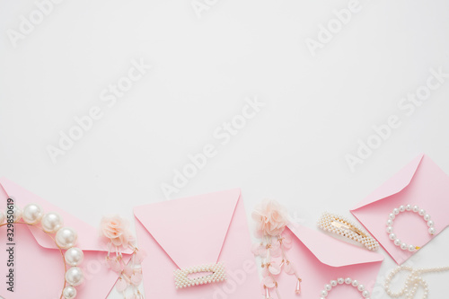 Wedding text background, white, decorated with pink invitation envelopes, top view, with copy space. The concept of a wedding date or a gentle background for the bride.