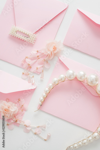 Wedding background, white with space for text, decorated with pink invitations, pearl jewelry, with copy space. Concept wedding flatly. © Карина Желнина