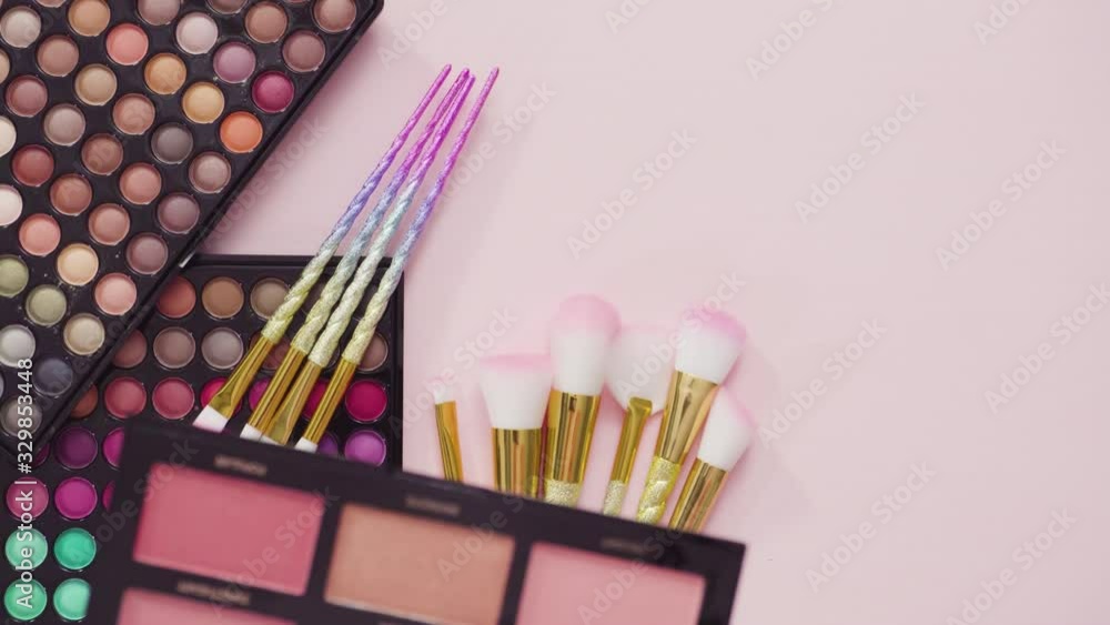 Flat lay. New eyeshadow palette with makeup brushes on a pink background. Flat lay. New eyeshadow palette with makeup brushes on a pink background.